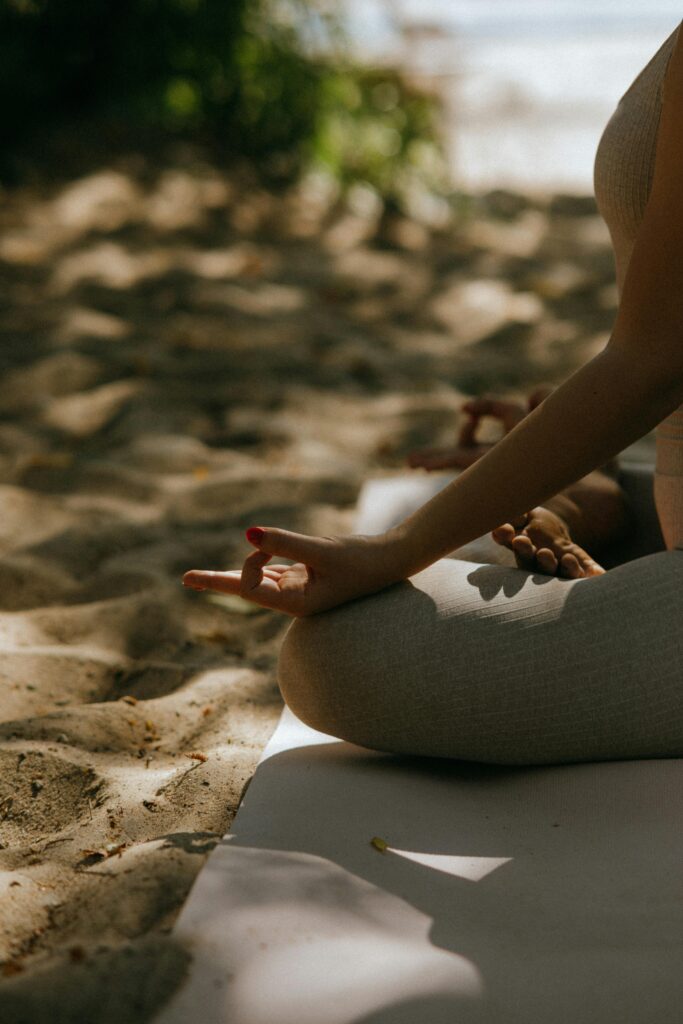 A peaceful scene of meditative yoga practice on a sandy beach.
