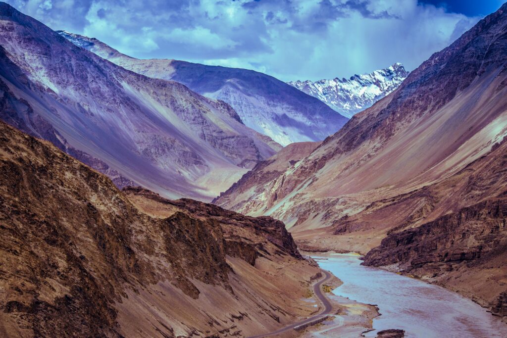 pexels-photo-570026-570026 Majestic view of a Himalayan valley with winding river beneath dramatic clouds.