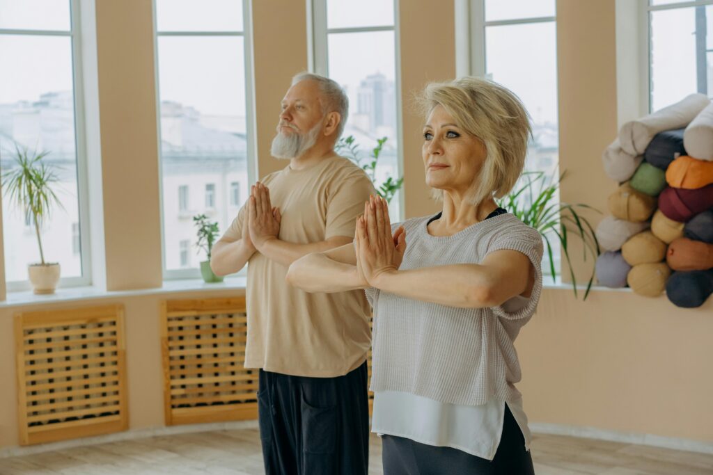 pexels-photo-7500318-7500318 Senior couple in a yoga studio practicing meditation poses, focusing on mindfulness and health.